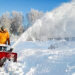 Mid adult man using snowblower -cm