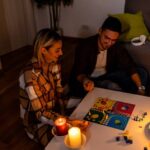 A young couple is suffering an electricity crisis at home and playing a ludo game-cm